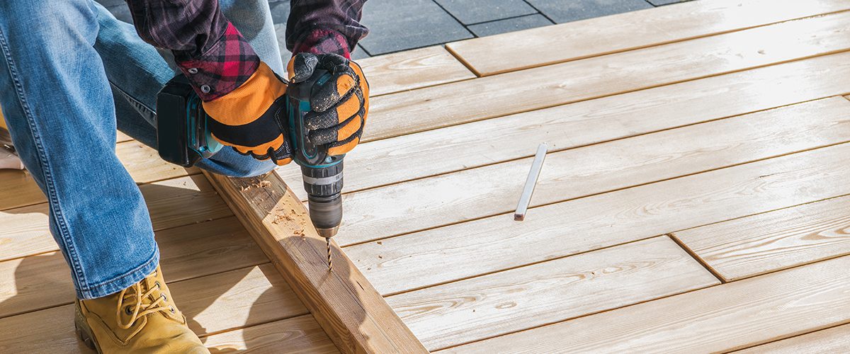 Construction Job. Men Drill Holes Inside Wood Planks. Small House Woodwork. Close Up Photo.
